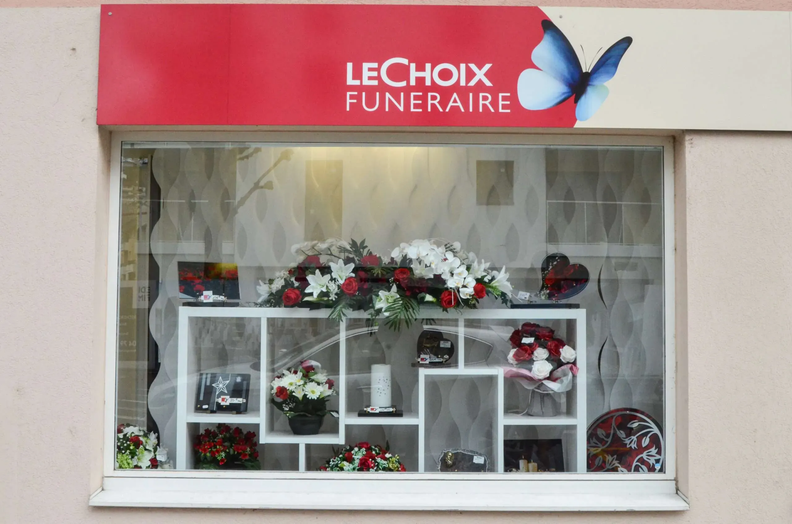 Devanture de l'agence Le Choix Funéraire avec articles funéraires en vitrine.